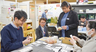 チームえんちかの従業員と和やかに作業する金澤さん（左）