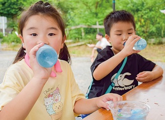 ラムネ片手に祭りを楽しむ子どもたち