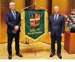 式典で披露された校旗と並ぶ中田センター長(右)と吉原義人副センター長