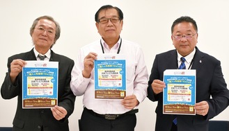 参加店に掲示されるポスターを手にする市商連の石川会長（中央）ら