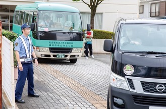 横浜市中山みどり園で送迎車の出発を見守る緑警察署員（提供写真）