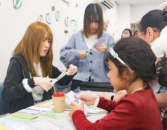 大学生と一緒に草花のしおりを制作