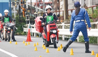 女性白バイ隊員の指導で講習を受ける郵便局員たち