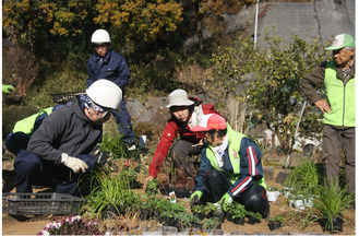 金子さん（右から３人目）の指導で、花壇に植え付けをする北八朔公園愛護会のメンバーら