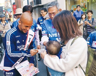 幼児と握手するマルコス選手