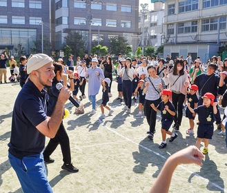 会場の英理女子高等学校のグラウンドで熱唱するグローバーさん(左)