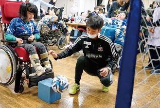 台の上にあるボールを蹴る児童