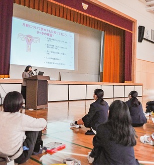 スライドを見せて解説する様子(21日､新羽中学校)