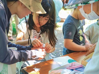 ワークショップで折り紙の紫陽花を作る子ども