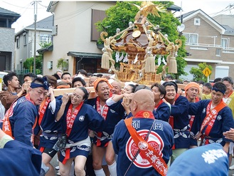 宮神輿を担ぎ、威勢のいい掛け声とともに街の中を練り歩く一行