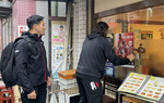 店頭にポスターを貼る嶋田選手