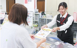 来局者に冊子を渡す職員