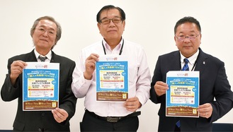 参加店に掲示されるポスターを手にする市商連の石川会長（中央）ら