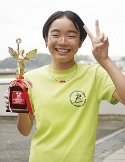 笑顔で優勝トロフィーを持つ東郷さん