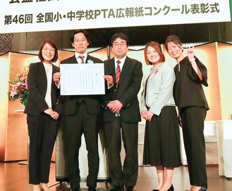 表彰状を手にする中川会長（写真中央は伊藤智樹校長）＝提供写真