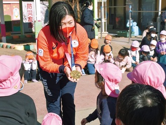 金メダルを見せながら、園児たちと交流する峰さん