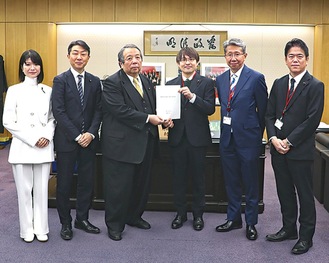 村上大臣（中央左）に要望書を手渡す川口氏（同右）。左から田中氏、古川直季総務大臣政務官、２人おいて鈴木議長、竹野内氏（横浜市提供）