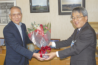 下村区長から祝いの花束を受け取る石田さん（左）