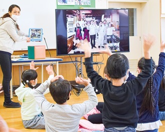 画面越しに手を振り合う伊勢山小の児童と社員たち