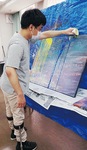 水で薄めた絵の具を流して描く本間さん