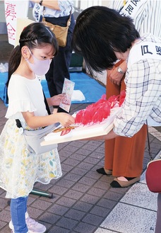 赤い羽根を受け取る少女