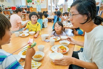 園児と給食を楽しむ生徒（右）