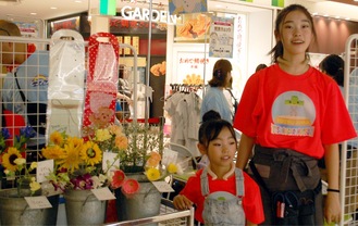 通行人に向けて花を販売するこどもたち