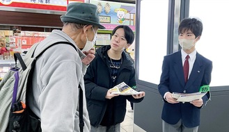 戸塚駅で通行人に特殊詐欺対策を訴える産業能率大学の学生（中央）と深谷中学校の生徒（右）