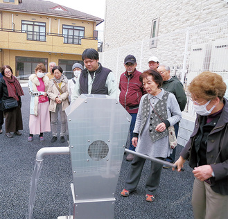 手動式の防災井戸を試用する地域住民