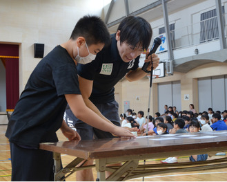 有安選手(右)と借り物競争を楽しむ児童