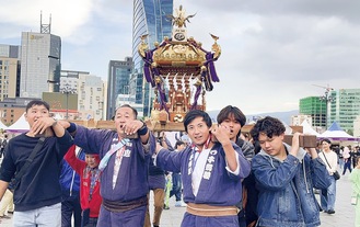 神輿を担ぐ宮田さん（中央右）と参加者＝宮田さん提供