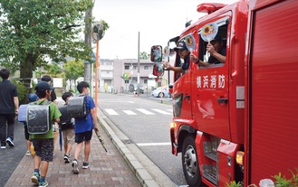 小学生にうちわを振る署員＝９月３日撮影