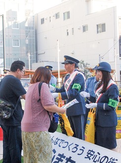 啓発グッズを配る波戸さんと小山さん