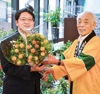 中川市長から紅花の花束を受け取る小林英二中区長