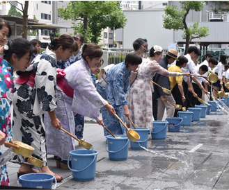 浴衣姿などで水を撒く参加者