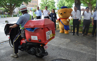 バイクを見送る関係者ら