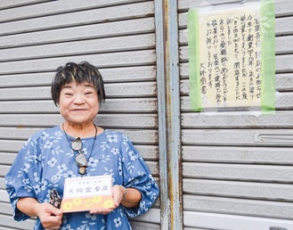 閉店の張り紙の前で、店主の佐藤さん