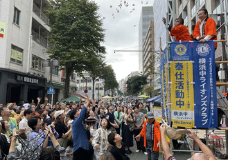 沢山の餅をキャッチしようと帽子や袋をかかげていた人も。大人から子どもまで盛り上がっていた