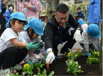 花を植える菊地健次区長と園児