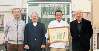 掲示板の前に集まる（左から）淺野副会長､渡邉会長､本多宮司､小山会長