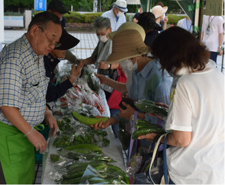 野菜を手にする来場者