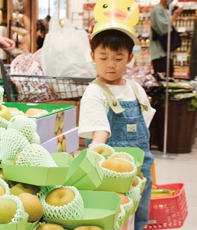 リストに書かれたナシを手にする子ども