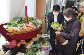 配付された野菜を手にする来店者