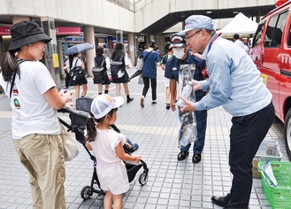 飲料とチラシを配布する藤原工場長と川村署長