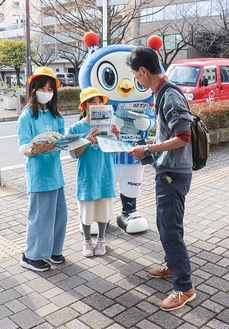 リーフレットを手渡す児童とフリ丸