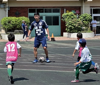 栗原さんとサッカーを楽しむ児童(C)1992 Y.MARINOS