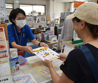 冊子を手渡す局員