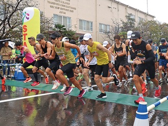 雨の中駆け出すランナーたち