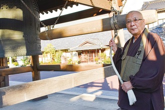 梵鐘の前に立つ守長住職