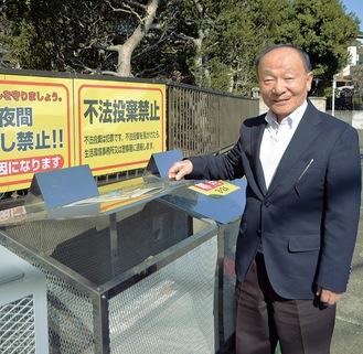 ステンレス製のごみ箱を開ける山田さん